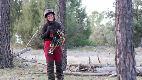 woman proudly smiling because of working in height pruning industry while untying a climbing rope for height pruning