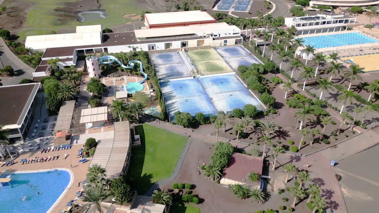grandes canchas de tenis, piscinas y toboganes de agua se ven en el resort playitas, españa