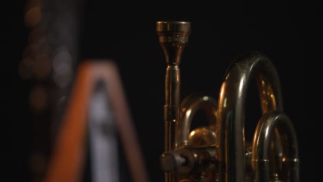 static shot of an analog metronome out of focus, against a dark background