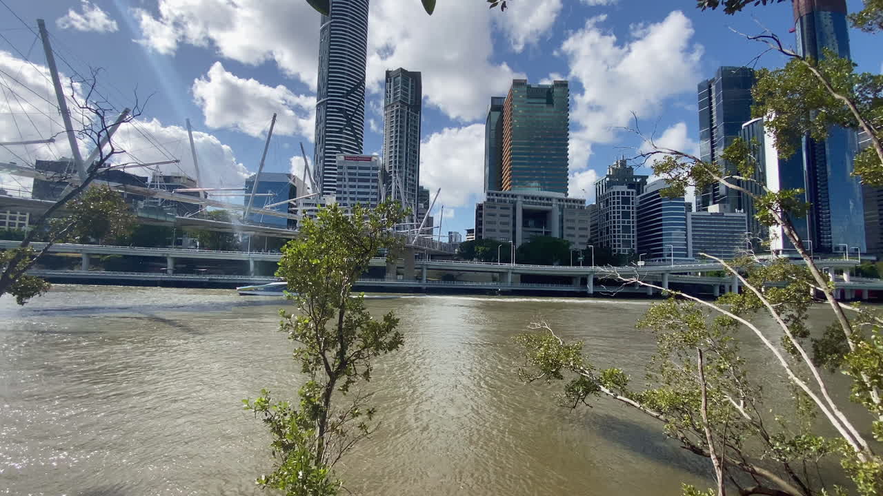 Panoramisk udsigt over City Cat-færgen på Brisbane-floden med bygninger og en bro i baggrunden, Queensland, Australien