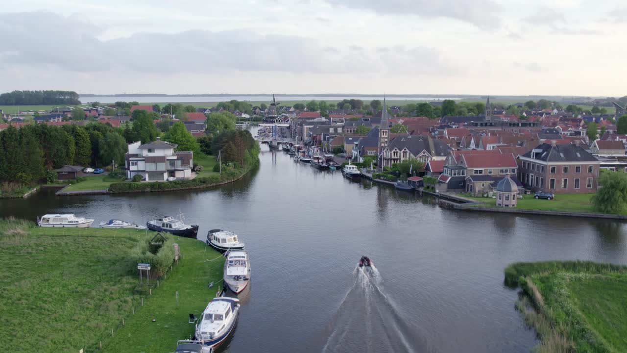 Barche sul fiume attraverso un tranquillo villaggio, Woudsend, Frisia, Paesi Bassi
