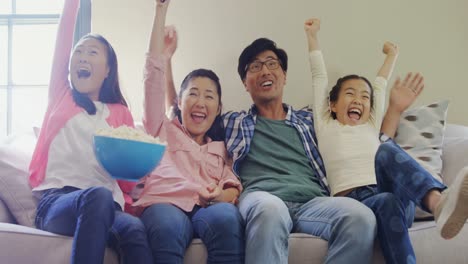 Excited-family-watching-television-together-in-living-room-4k