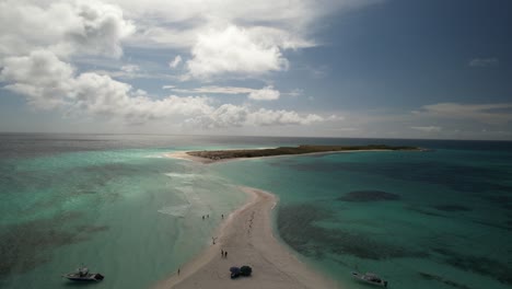 aerial view of a tropical sandbar in turquoise waters with boats and people