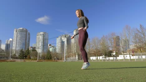 young woman skipping in city park slow motion wide shot