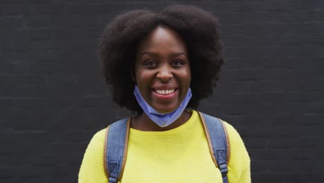 Portrait-of-african-american-wearing-face-mask-in-street