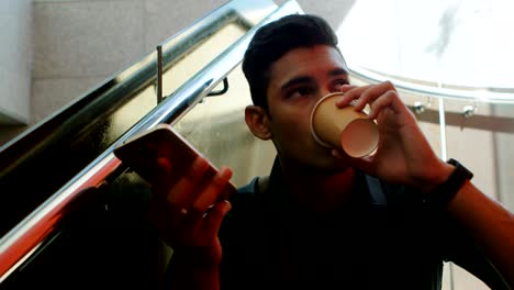 viajero masculino hablando por teléfono móvil mientras toma café 4k