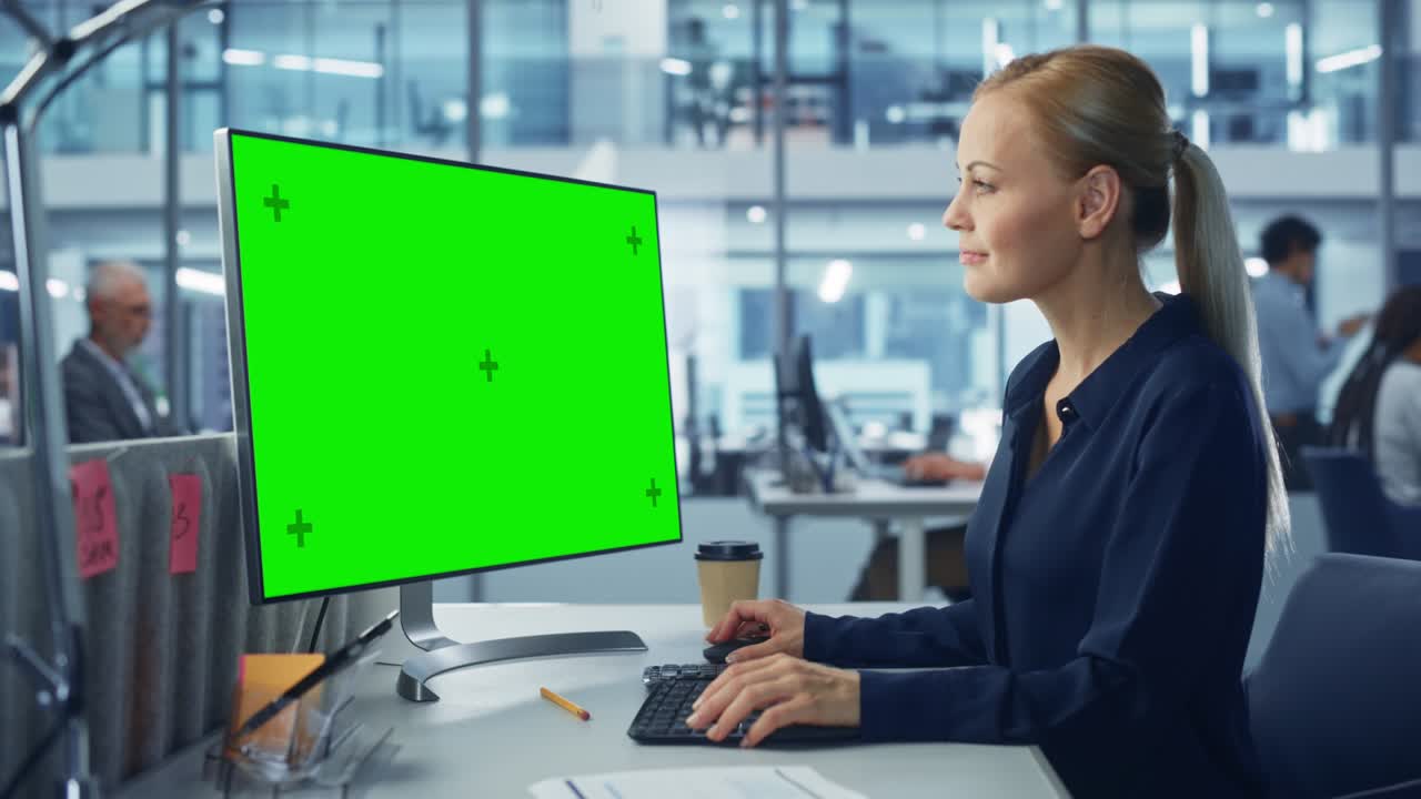 ufficio moderno diversificato: donna d'affari sicura che utilizza un computer desktop con schermo verde. manager che lavora sul supporto del commercio elettronico, il marketing dei progetti, l'analisi dei dati