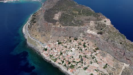 drohnen-aufnahme von häusern im dorf monemvasia in griechenland, umgeben von meer