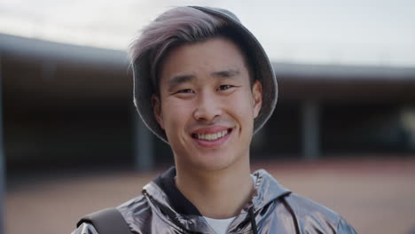 close up portrait happy young asian man student smiling enjoying relaxed urban lifestyle wearing stylish silver jacket real people series