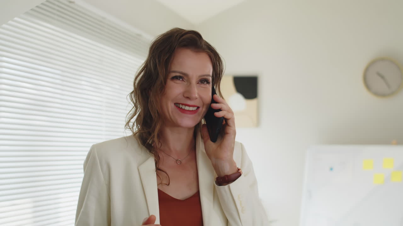Cheerful Businesswoman Talking with Business Partner on Smartphone
