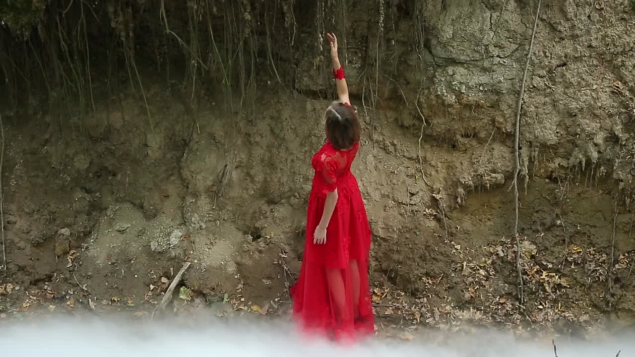 Woman In Forest In Cloud Of Smoke. Woman long red dress in forest in cloud of smoke