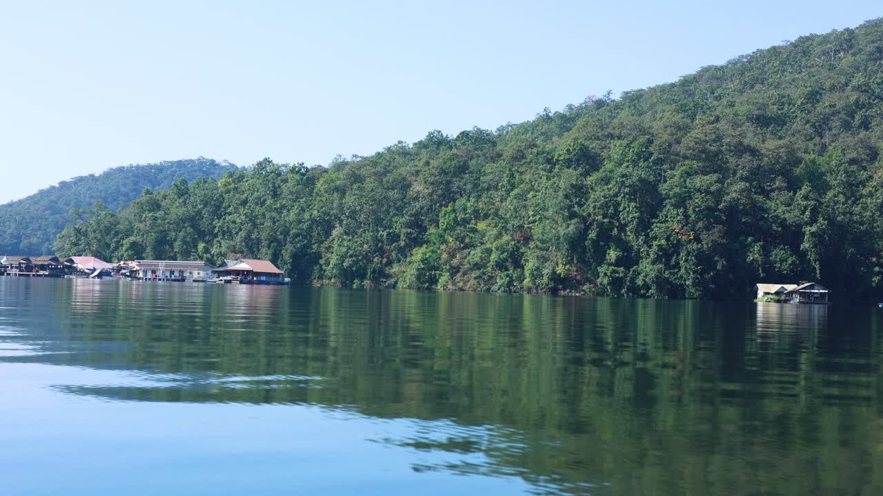 agua tranquila, casas flotantes, vegetación exuberante, cielo despejado