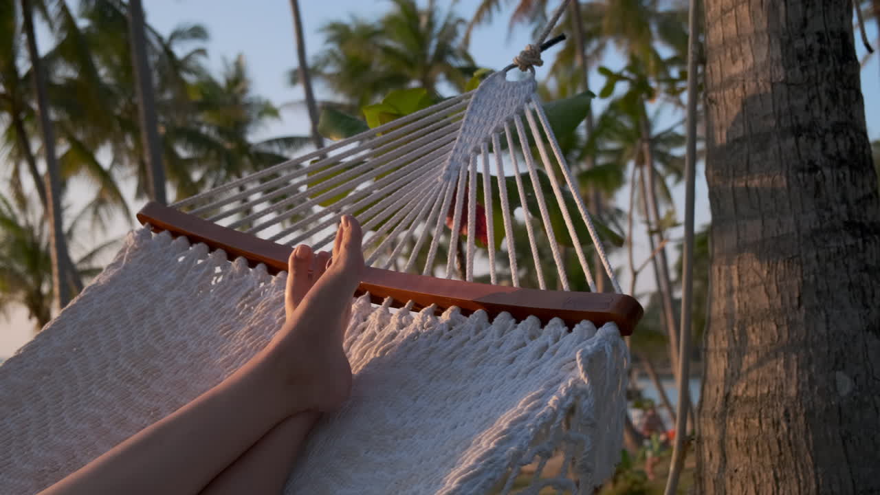 relajándose en una hamaca en una playa tropical al atardecer