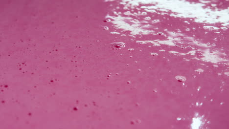 close-up shot of bubbles popping from the poured out milkshake mix