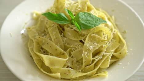 pesto fettuccine pasta with parmesan cheese on top - italian food style