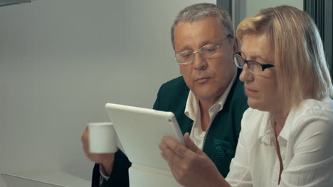 Woman-using-tablet-man-drinking-coffee