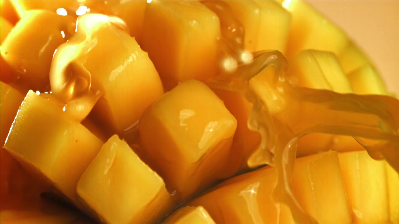 Cubetti di mango dolce irrorati con sciroppo dorato al rallentatore