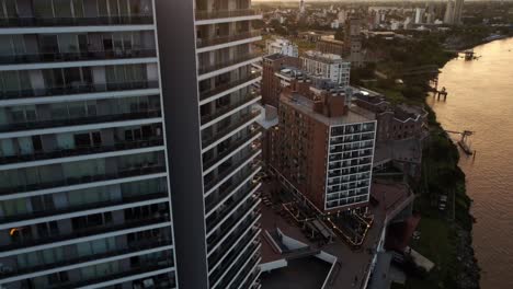 Toma-Aérea-De-Edificios-Residenciales-En-Puerto-Norte-Atardecer,-Argentina-A-Lo-Largo-De-Las-Orillas-Del-Río-Paraná-En-La-Noche-Durante-La-Puesta-De-Sol