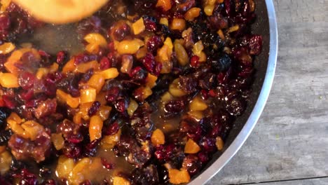 simmering-dried-fruits-and-zest-of-orange-and-lemons-for-holiday-fruit-cake-flat-lay