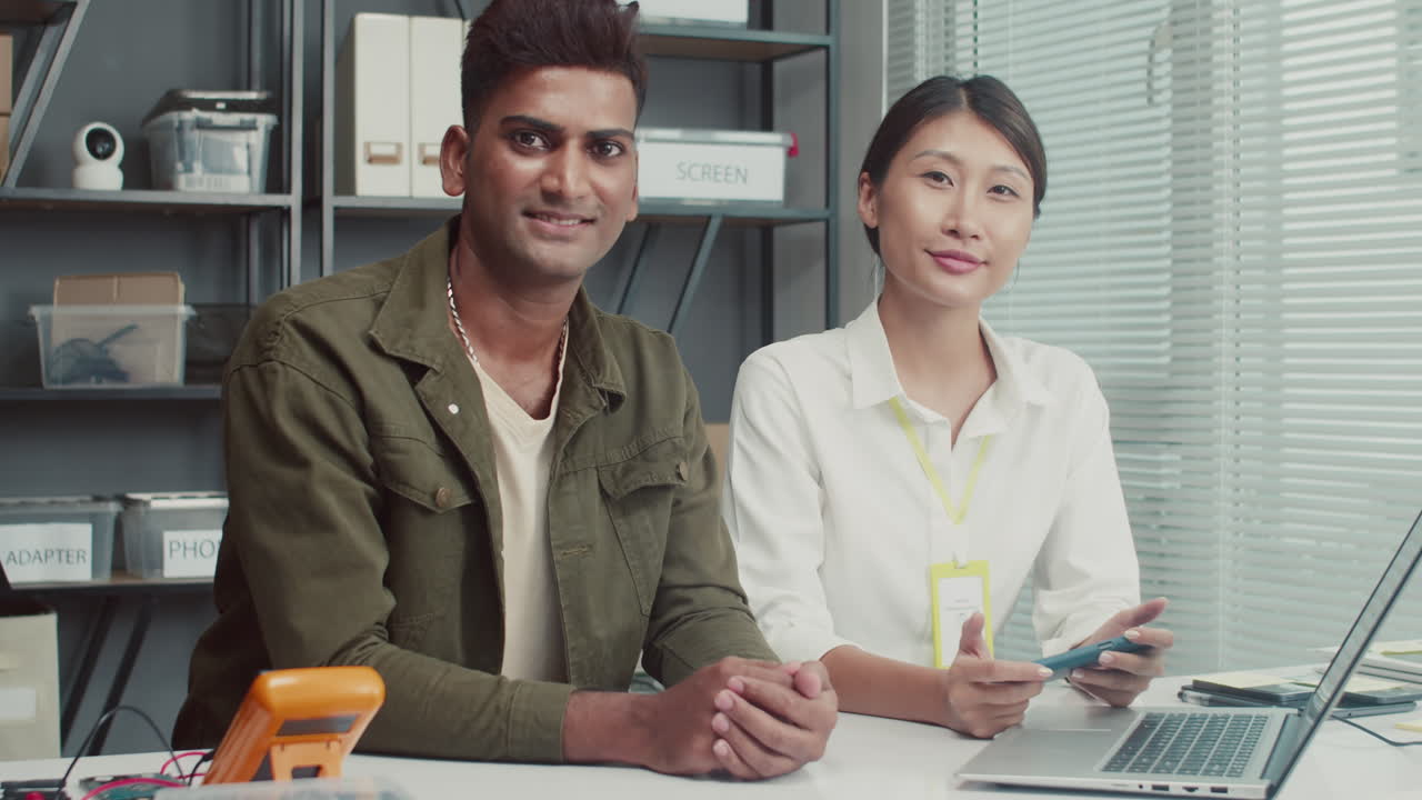 Portrait of Female Technician and Male Client Discussing Smartphone Work