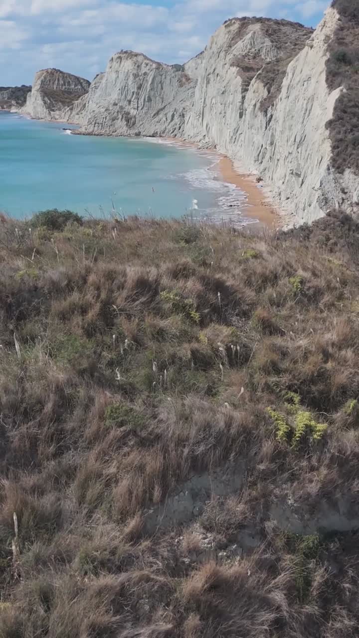 Paesaggio costiero con scogliere bianche e spiaggia di sabbia rossa