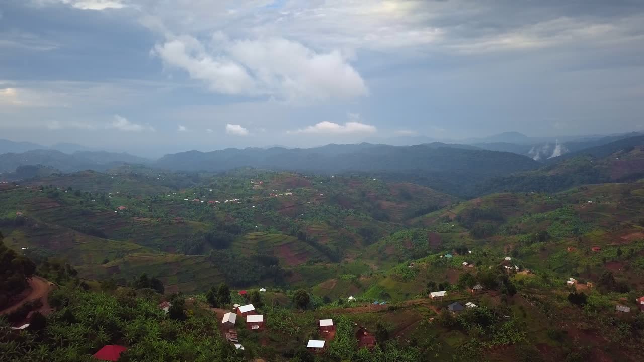 Rural farmland and village landscape revealed through forest opening in Kanungu District near Bwindi Impenetrable National Park, Western Region, Uganda, East Africa, aerial drone view