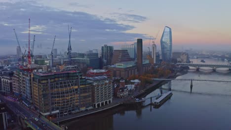 Falling-crane-drone-shot-of-southwark-Blackfriars-thames-river-bank-at-sunrise