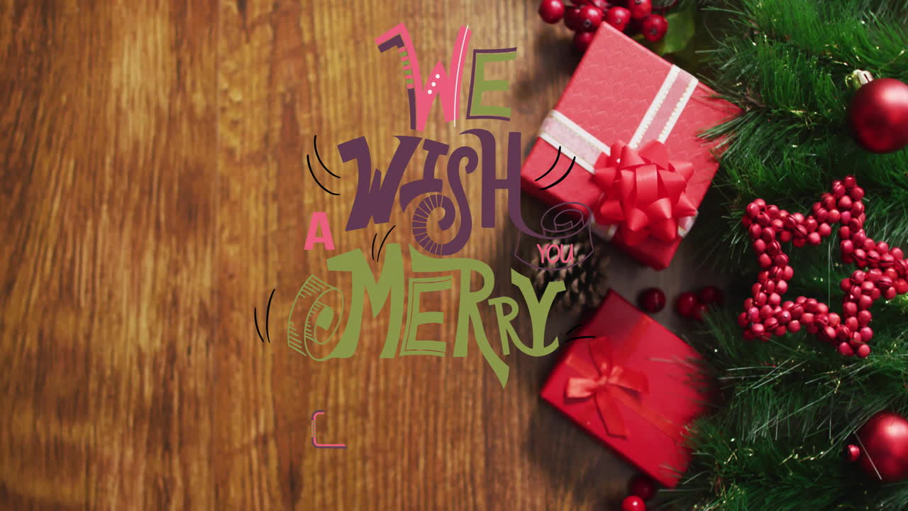 Animation of we wish you a merry christmas text over christmas decorations on wooden background