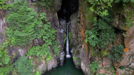 Drone-dolly-toward-scenic-Salto-do-Cabrito-waterfall-in-canyon,-São-Miguel