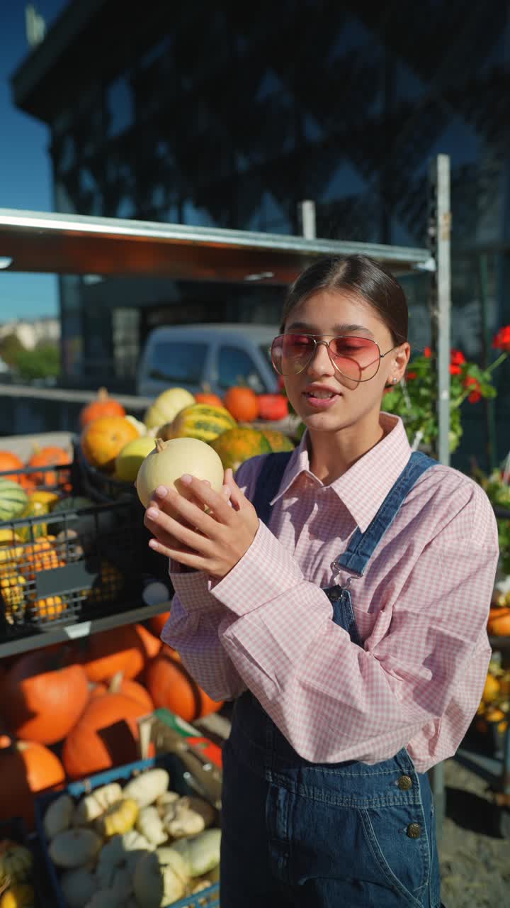 mujer comprando calabazas en un mercado de agricultores