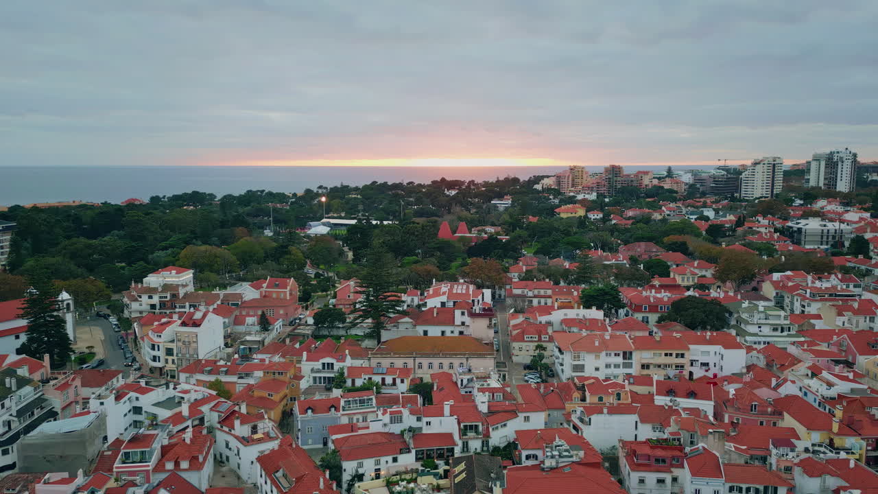 Aerial cityscape basking sunset glow with orange sky. Twilight on urban skyline