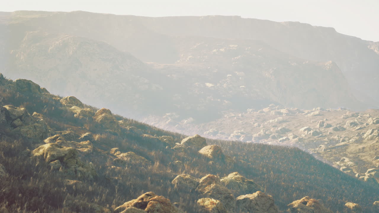 Scenic view of rolling hills and rocky terrain during the golden hour