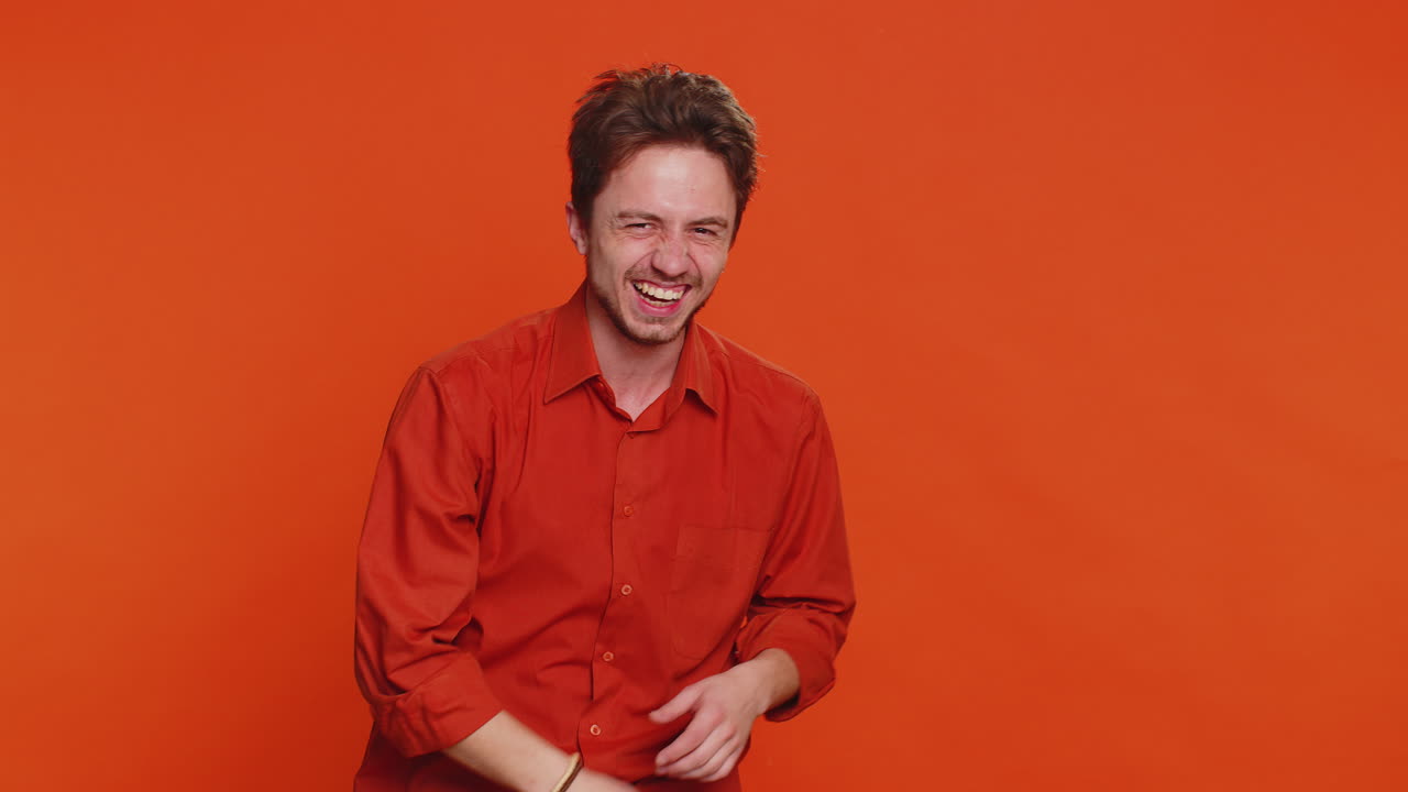 Un giovane felice e eccitato che ride ad alta voce dopo aver sentito una ridicola reazione aneddotica a uno scherzo divertente