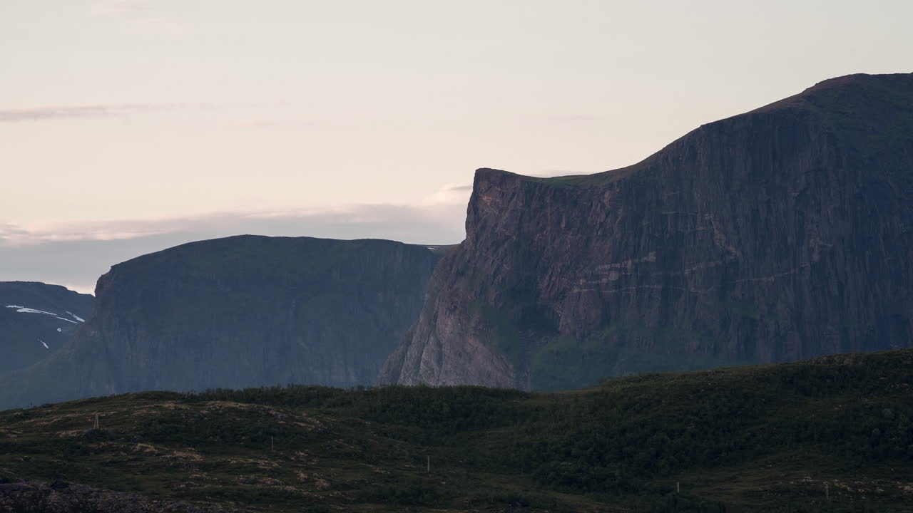 timelapse del sol rojo de medianoche golpeando una montaña aguda en senja en el norte de noruega