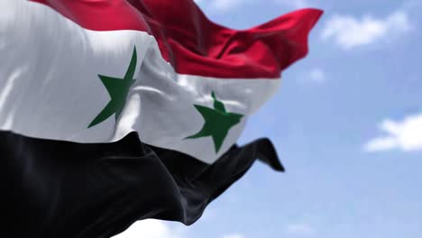 detail of the national flag of syria waving in the wind on a clear day