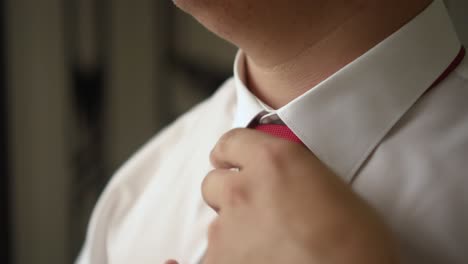 man adjusts collar and tie