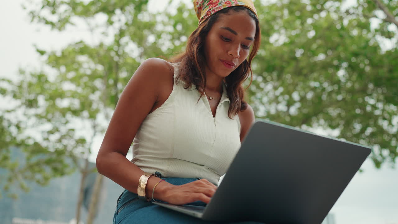 mujer trabajando en la computadora portátil al aire libre