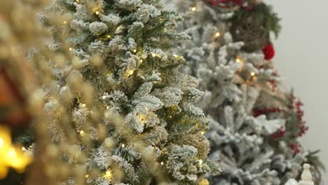 artificial christmas trees decorated with lights in shop window. 4k.
