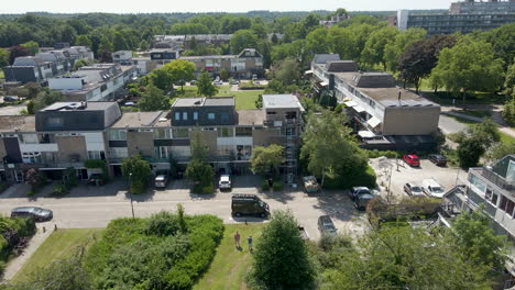 Aerial-towards-row-of-houses-with-one-house-under-renovation-in-a-green-suburban-neighborhood