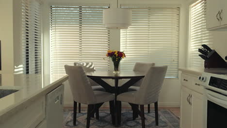 a cozy kitchen setting with a small dining table, soft lighting, and modern appliances
