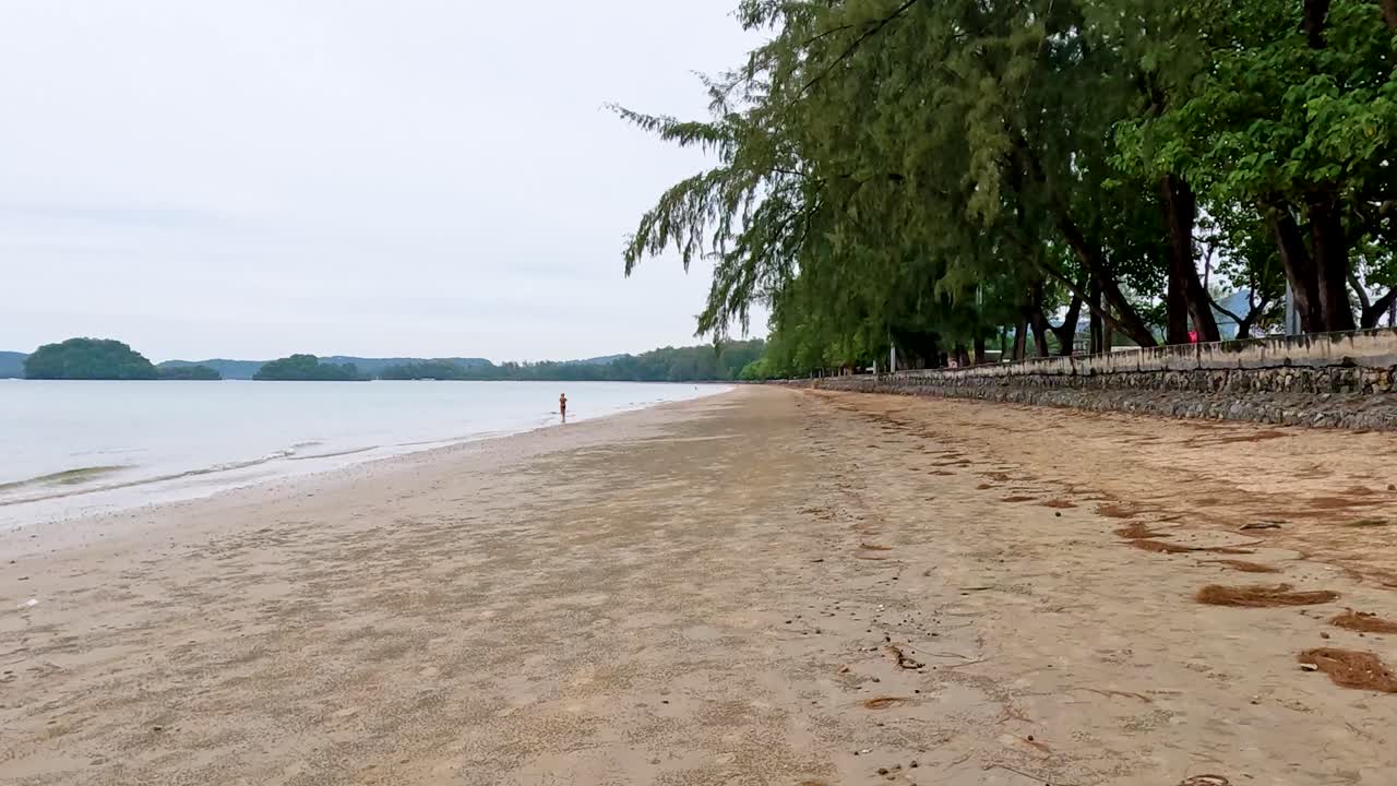persona caminando sola en una playa tranquila en krabi, tailandia