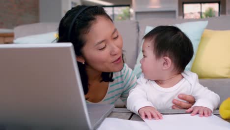 mother with baby using laptop