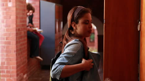 estudiante caminando hacia su casillero y abriéndolo