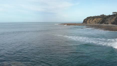 antena delantera sobre el océano con pequeñas olas rompiendo en un arrecife en la costa de victoria's bass