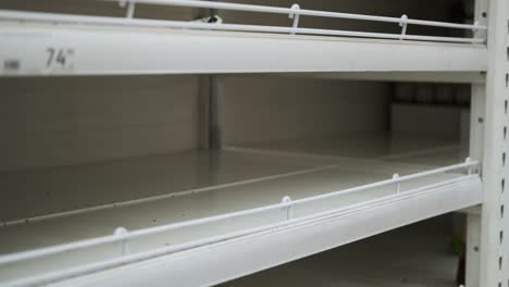 taking packages of rise from empty store shelf