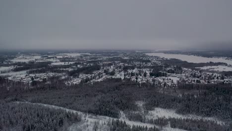 Vista-Aérea-De-Un-Pequeño-Pueblo-En-Un-Bosque-Nevado-Y-Frío