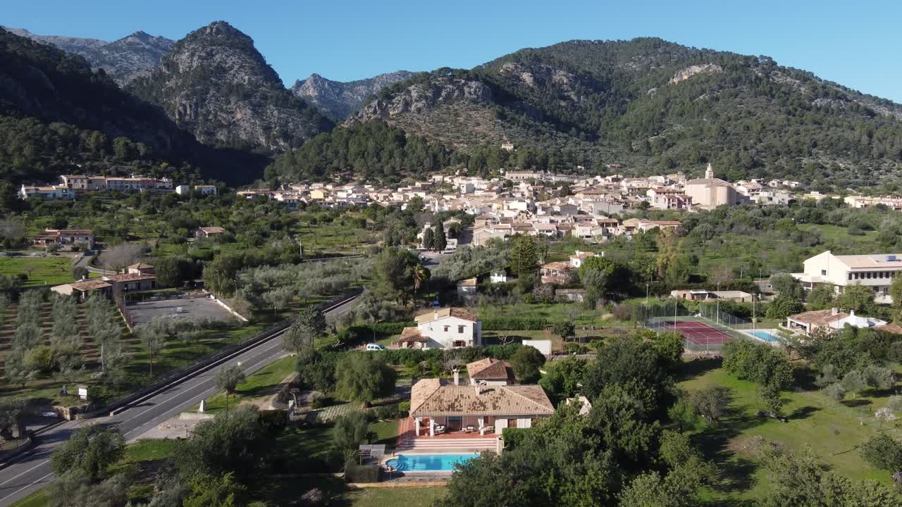 Tiefflug auf das Dorf Caimari zu, mit dem Tramuntana-Gebirge im Hintergrund. Mallorca, Spanien