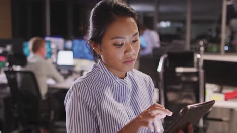 professional businesswoman using a digital tablet while sitting in modern office in slow motion