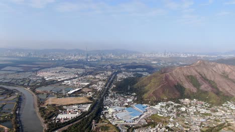 Hong-Kong-and-Shenzhen-border-line-over-Hong-Kong-rural-houses-with-Shenhzen-skyline-in-the-horizon,-Aerial-view