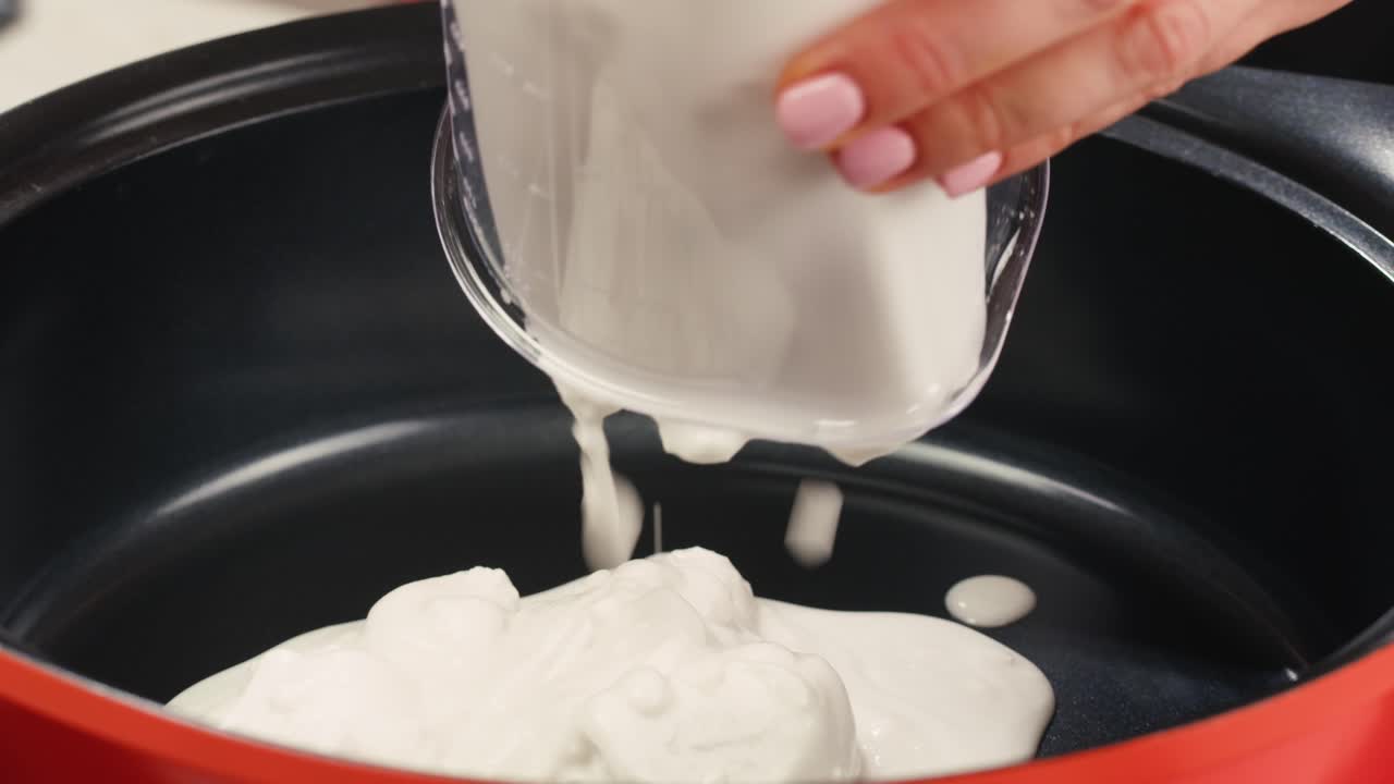 Pouring cream into a cooking pot